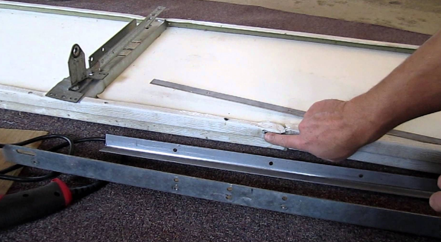 A skilled technician performing garage door panel repair in Jupiter, FL, demonstrating professional garage door repair services.