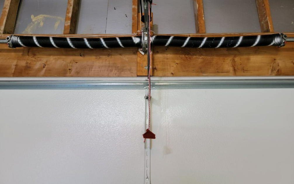 Technician performing professional garage door spring repair in Jupiter, FL to ensure safe and efficient garage door operation.