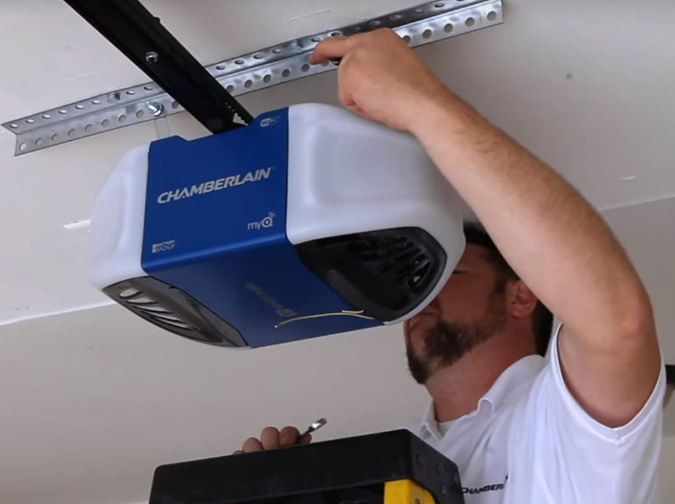 A skilled technician repairing a garage door opener mechanism, showcasing expertise and precision in maintenance work. Alt text: "Technician expertly repairing garage door opener mechanism for optimal performance in Jupiter, FL