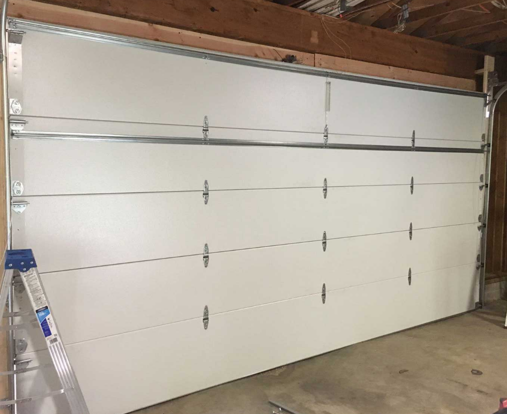 Alt text: A professional technician installing a new garage door for a residential home in Jupiter, FL, showcasing expertise in garage door replacement services.