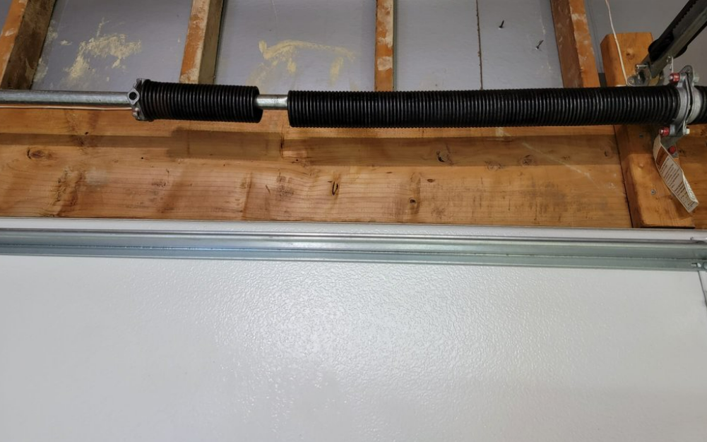 Technician performing professional garage door spring repair in Jupiter, FL to ensure safe and efficient garage door operation.